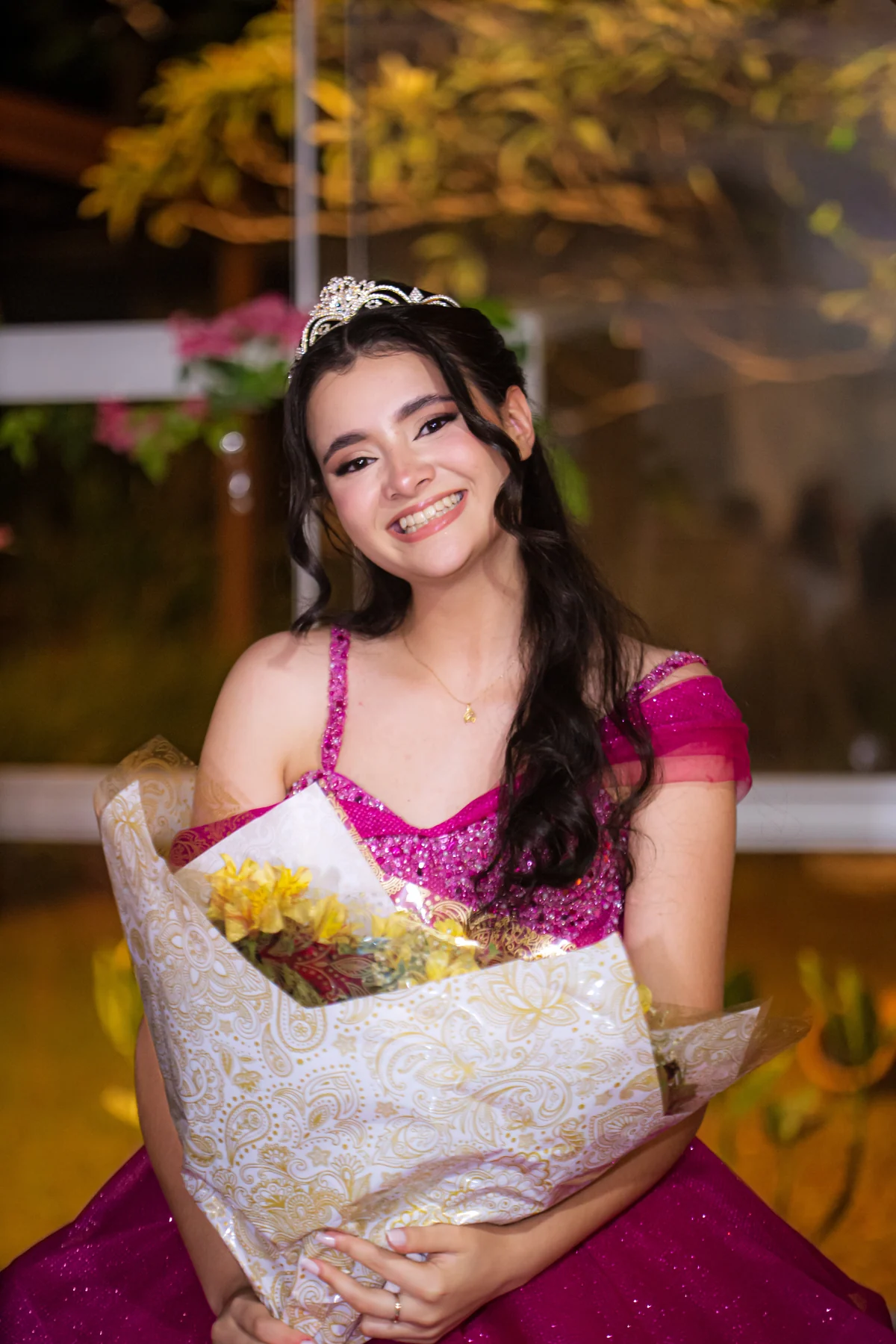 Debutante sorrindo com buquê de flores durante a festa de 15 anos